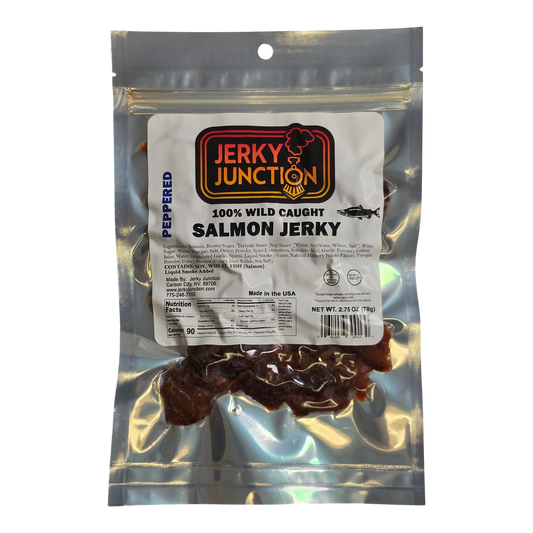 Jerky Junction Peppered Salmon Jerky front, clear silver bag, white label, dark reddish-brown salmon pieces visible below