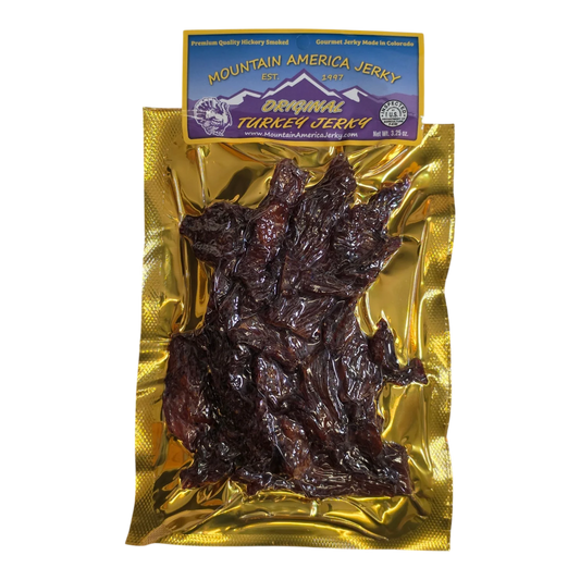 Mountain America Jerky Original Turkey Jerky front: gold bag with dark, glossy hickory smoked turkey strips visible