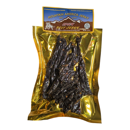 Mountain America Jerky Spicy Beef Jerky front, gold bag with window showing dark smoked beef strips flecked with red pepper