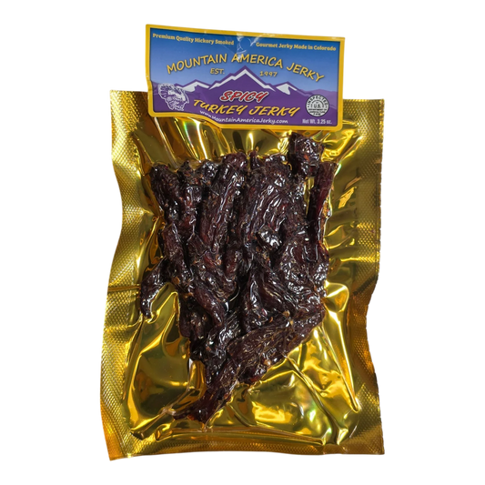 Mountain America Jerky Spicy Turkey Jerky front: gold bag, purple label, window showing dark spiced turkey strips